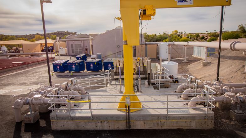 A yellow crane with a yellow pipe attached to it.