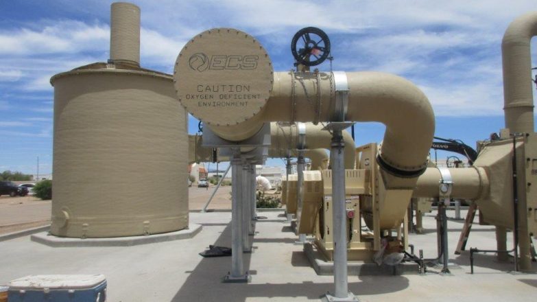 A tan building with a pipe in the middle of it.